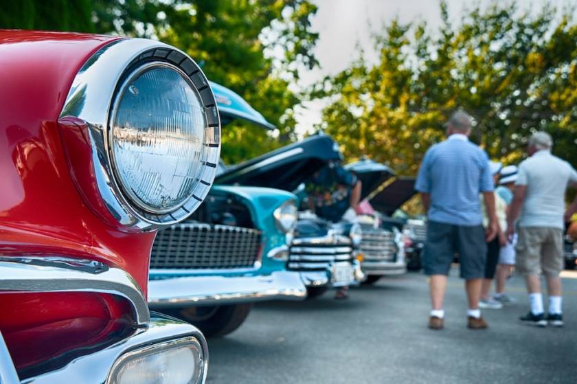 Folks viewing classic cars at an outdoor car show