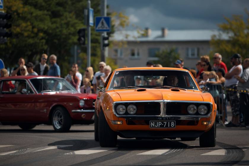 classic cars driving in a parade at a car show event